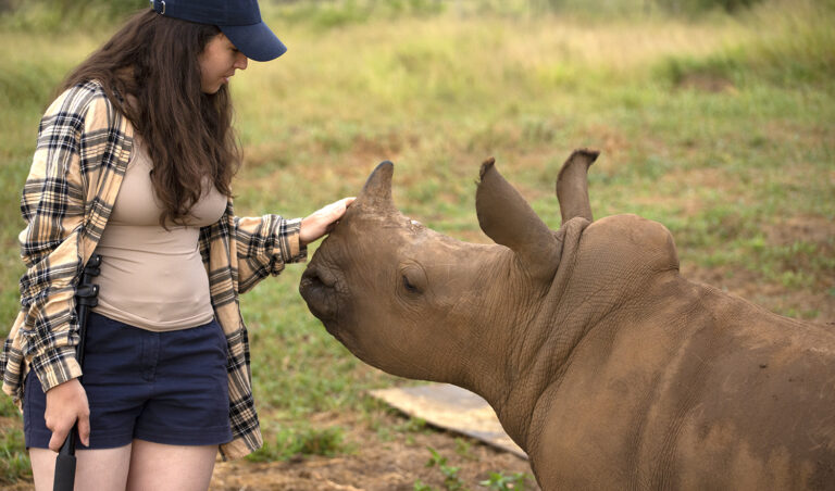 Megan McCubbin petting a rhino